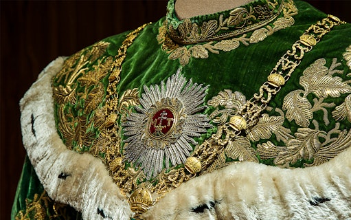Ornate green and gold robe with intricate embroidery at Imperial Treasury Vienna.