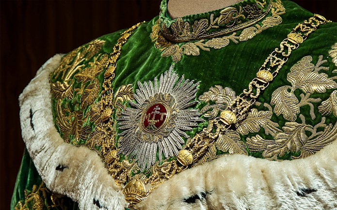 Ornate green and gold robe with intricate embroidery at Imperial Treasury Vienna.