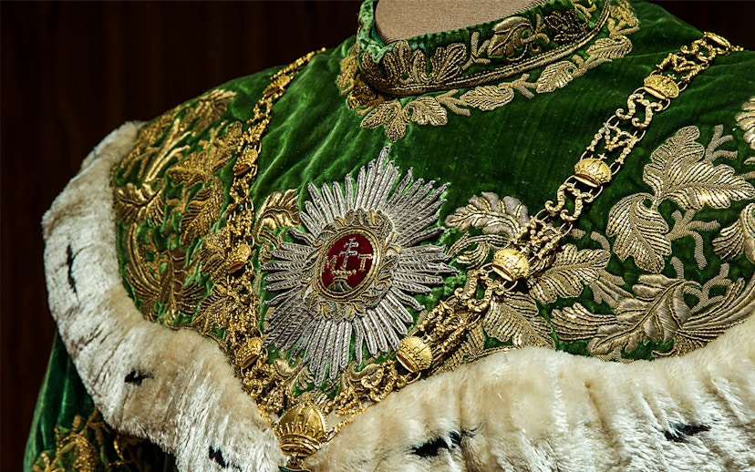 Ornate green and gold robe with intricate embroidery at Imperial Treasury Vienna.