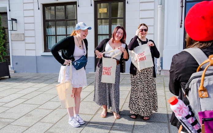 Tourists smiling and holding bags during Emily in Paris Locations Walking Tour.