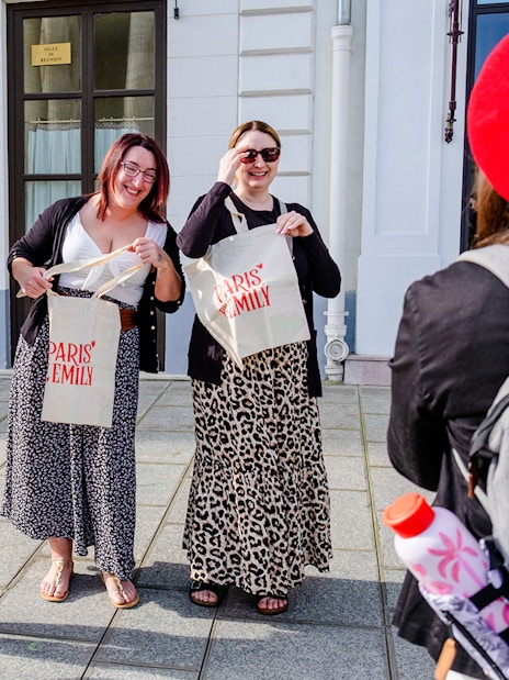 Tourists smiling and holding bags during Emily in Paris Locations Walking Tour.