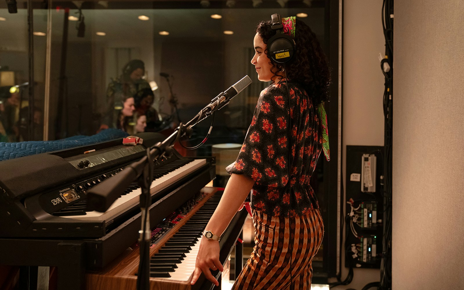 Musician recording vocals in a studio with a keyboard, related to Stereophonic tour.