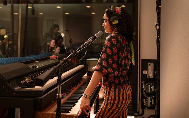 Musician recording vocals in a studio with a keyboard, related to Stereophonic tour.