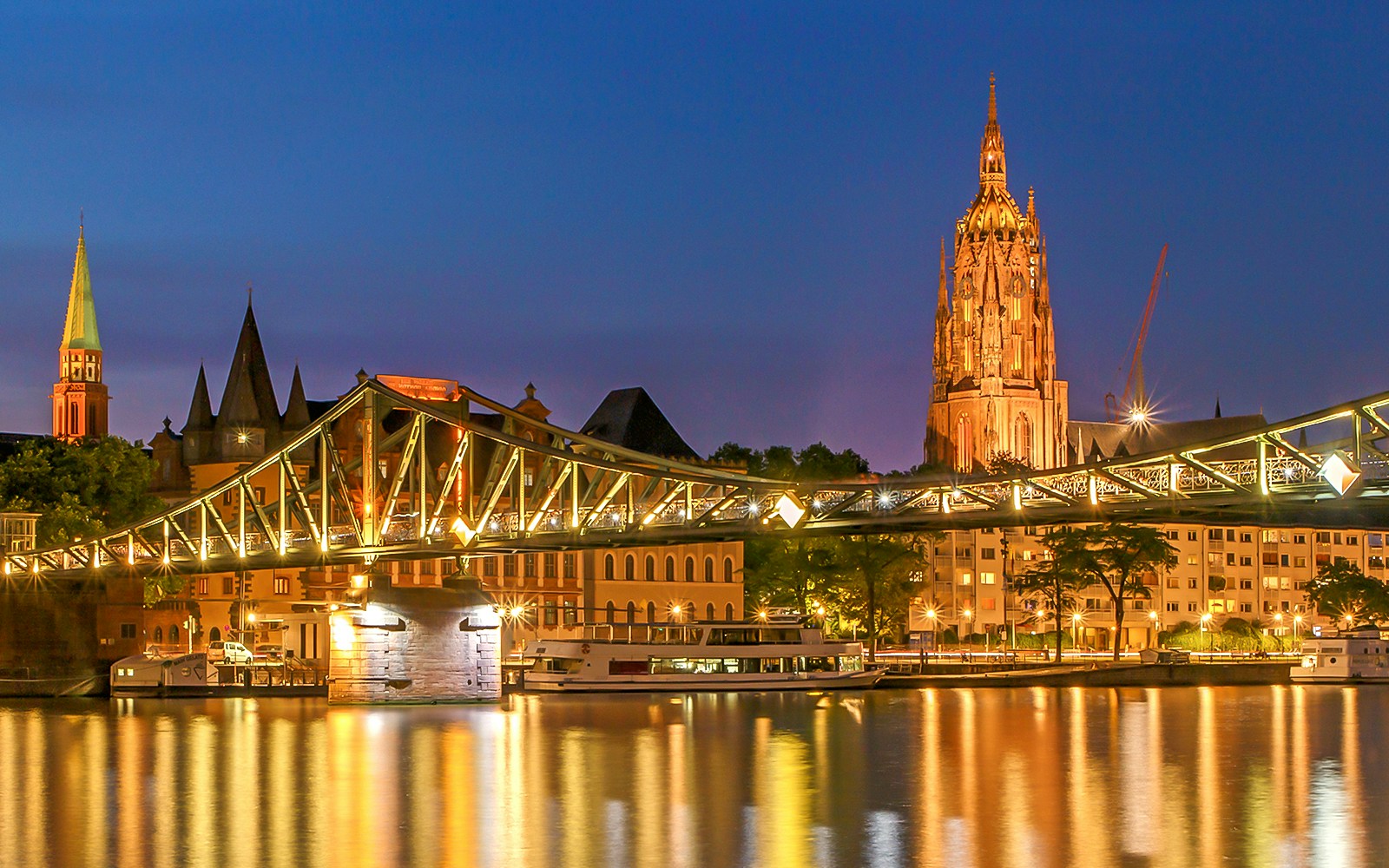 Frankfurt Cathedral illuminated at dusk seen from a river cruise.