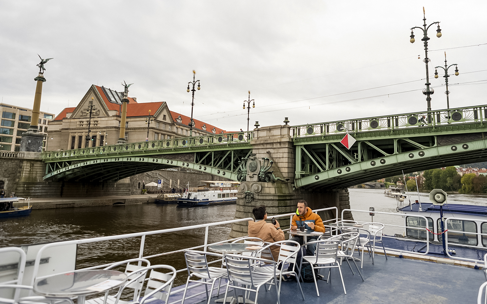 Guests enjoying views of a historic bridge during a boat tour in Prague.