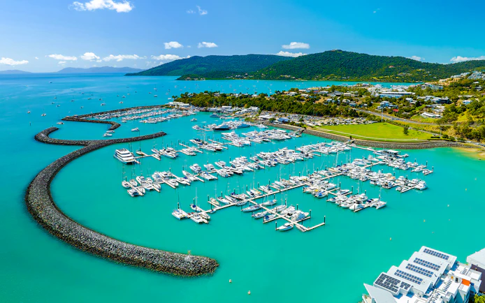 Coral Sea Marina in Airlie Beach with yachts and turquoise waters.