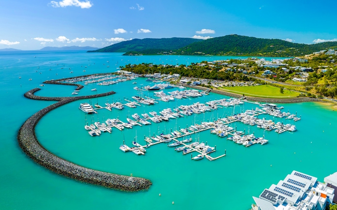 Coral Sea Marina in Airlie Beach with yachts and turquoise waters.