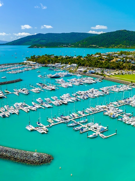 Coral Sea Marina in Airlie Beach with yachts and turquoise waters.