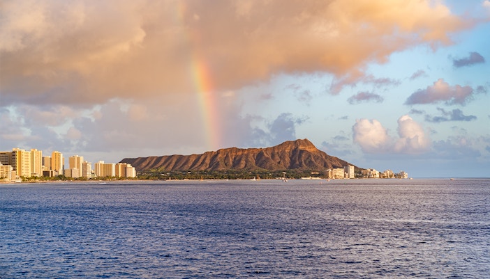 Rainbow over Diamond Head mountain at sunset, viewed from a cruise in Honolulu.