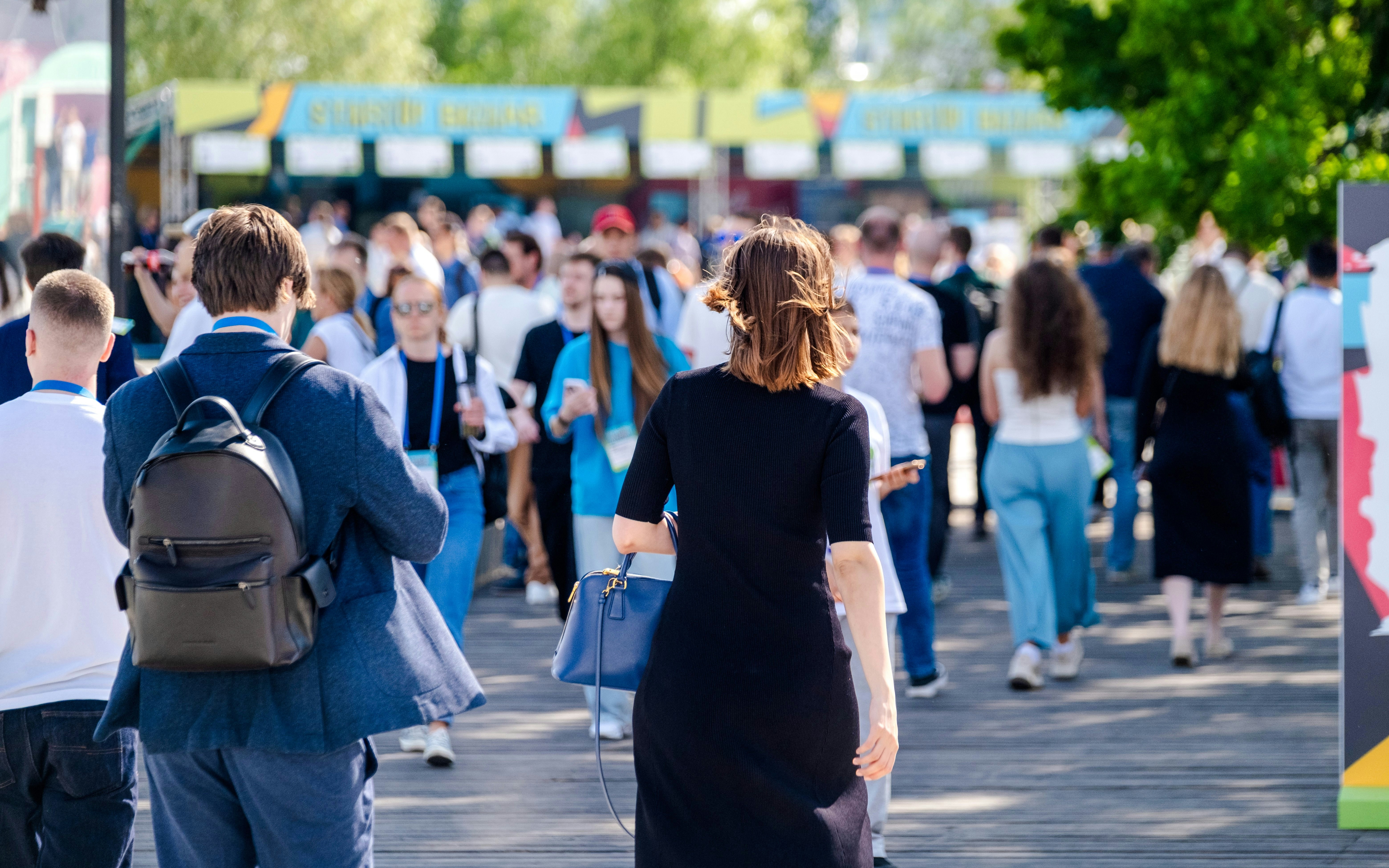 Crowd walking through an exhibition space in London.