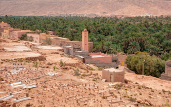 Palm grove and village in Ziz Valley, Morocco, with desert landscape.