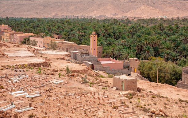 Palm grove and village in Ziz Valley, Morocco, with desert landscape.