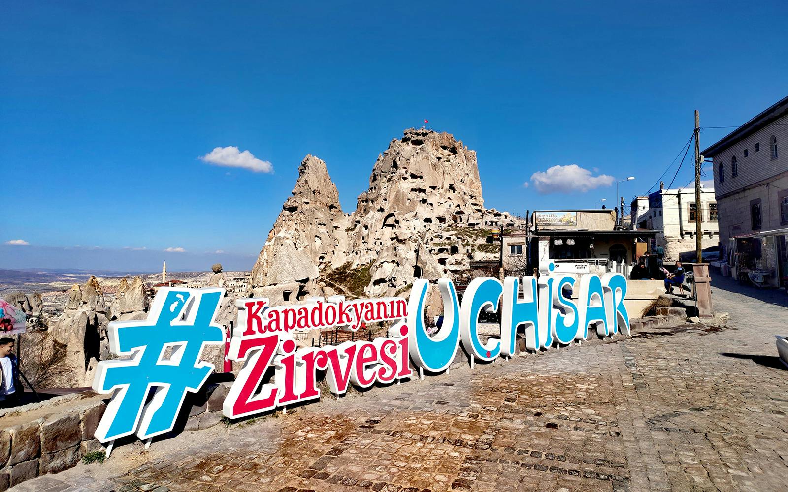 Uchisar Castle with large sign in Cappadocia, Turkey.