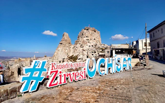 Uchisar Castle with large sign in Cappadocia, Turkey.