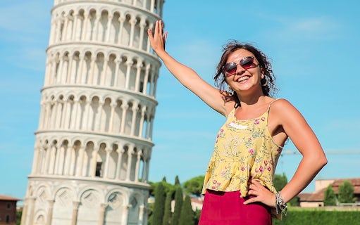 Smiling tourist posing with the Leaning Tower of Pisa during a guided tour from Florence.