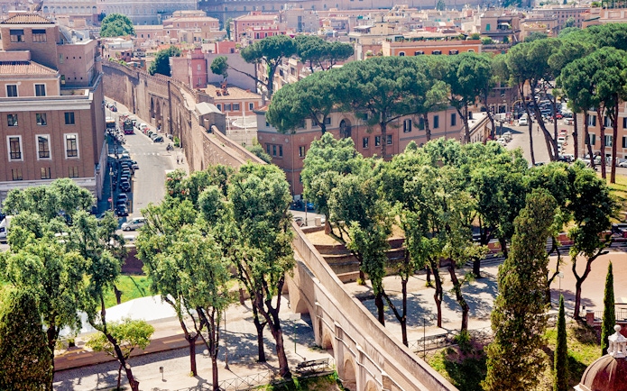Passetto di Borgo connecting to Vatican City, surrounded by trees and historic buildings.