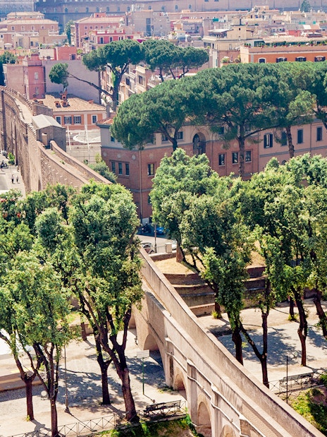 Passetto di Borgo connecting to Vatican City, surrounded by trees and historic buildings.