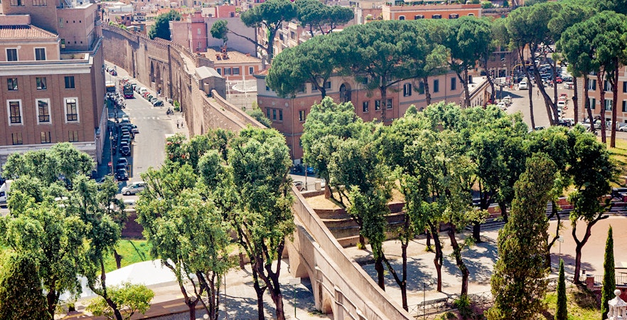 Passetto di Borgo connecting to Vatican City, surrounded by trees and historic buildings.