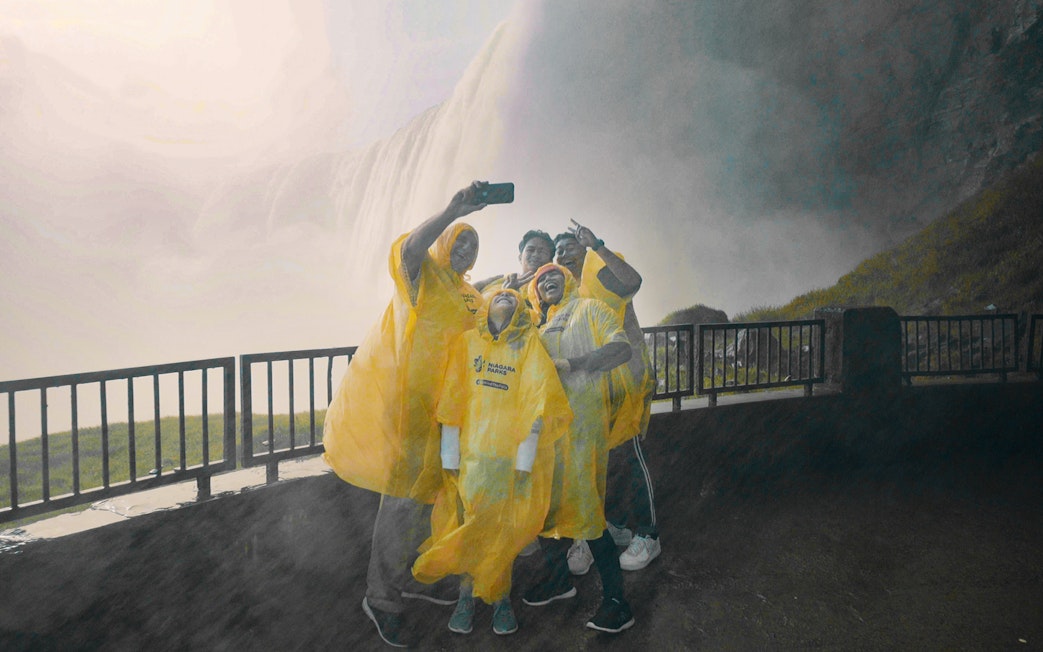 Visitors in yellow ponchos taking a selfie near Niagara Falls, Canada.