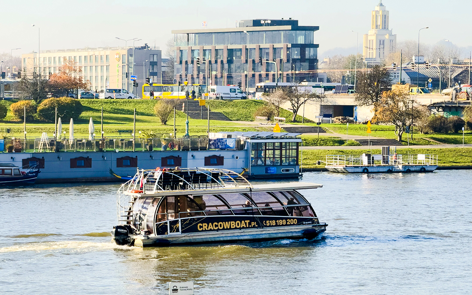 Cruise boat on the Vistula River with cityscape in Krakow, Poland.