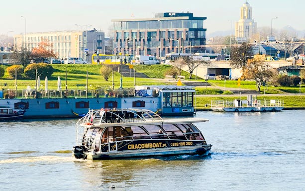 Cruise boat on the Vistula River with cityscape in Krakow, Poland.