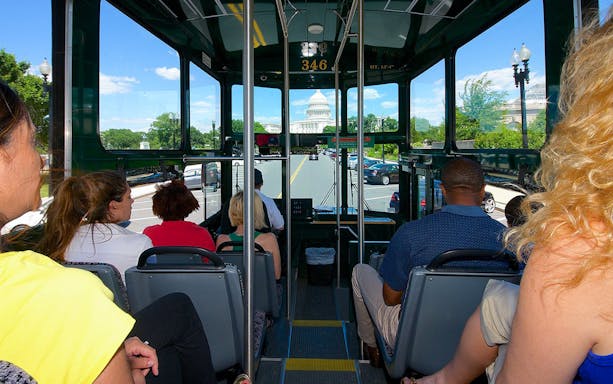 Double-decker bus touring past the Washington Monument in Washington DC.