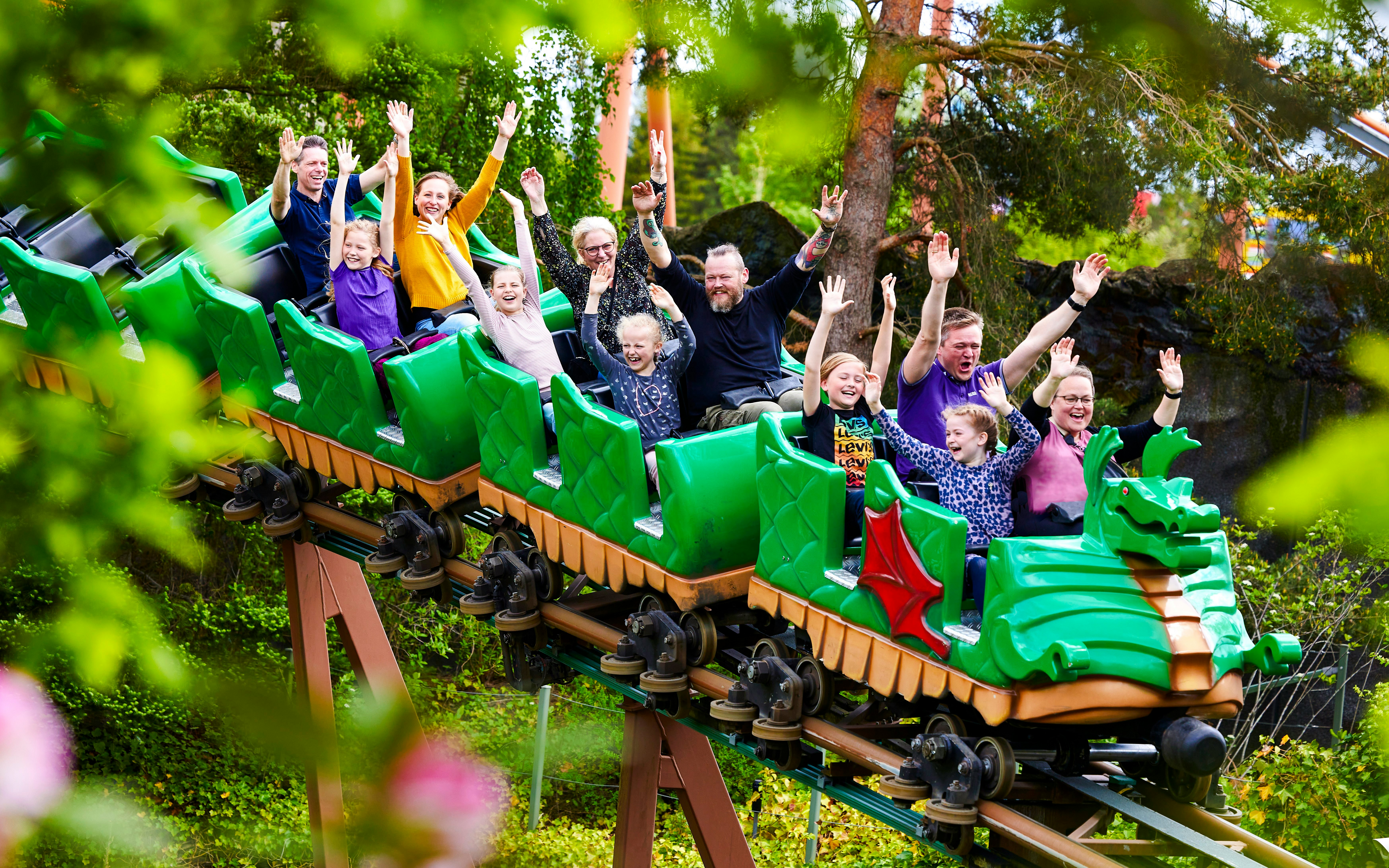 Visitors enjoying a dragon-themed roller coaster at LEGOLAND Billund.