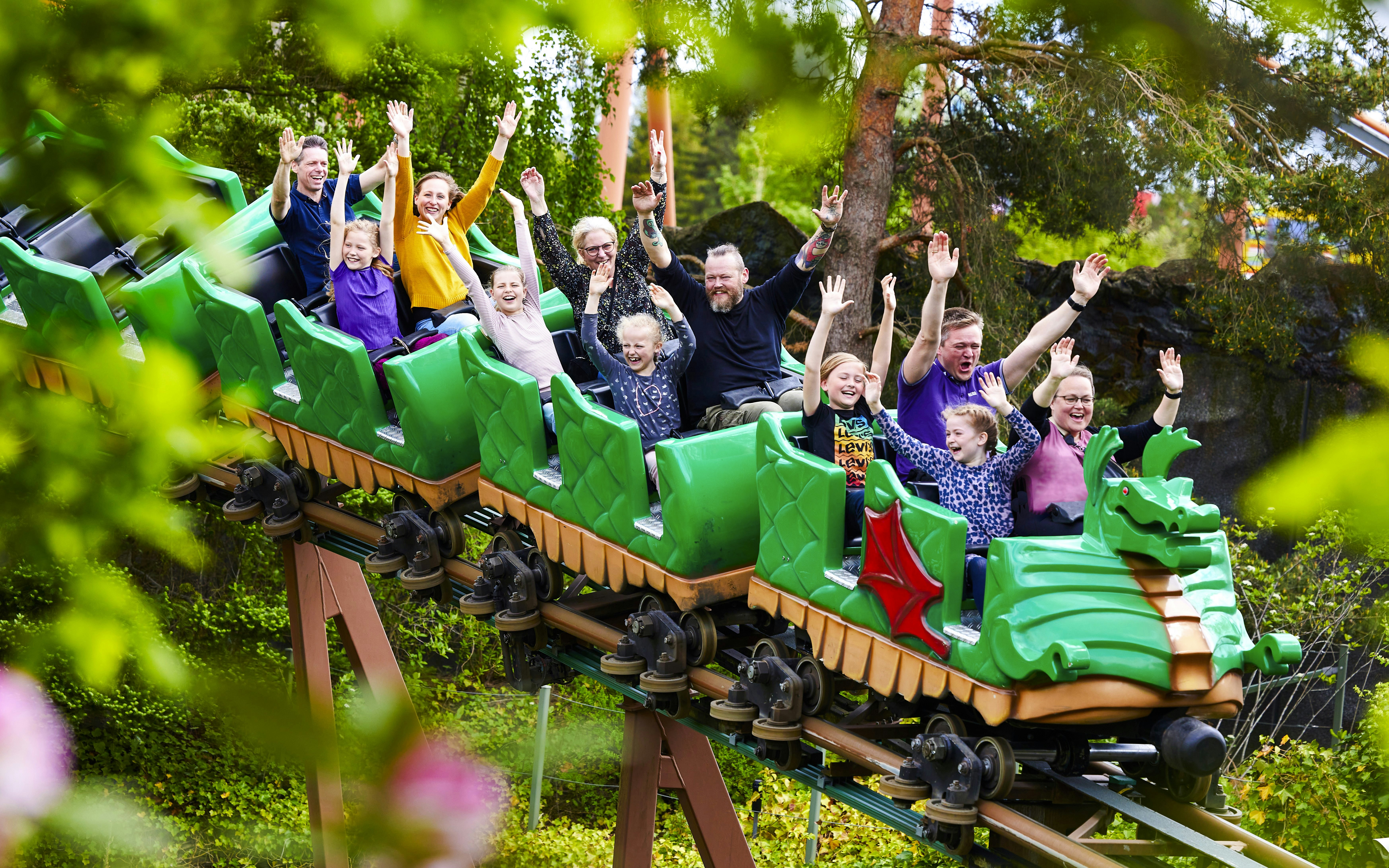 Visitors enjoying a dragon-themed roller coaster at LEGOLAND Billund.