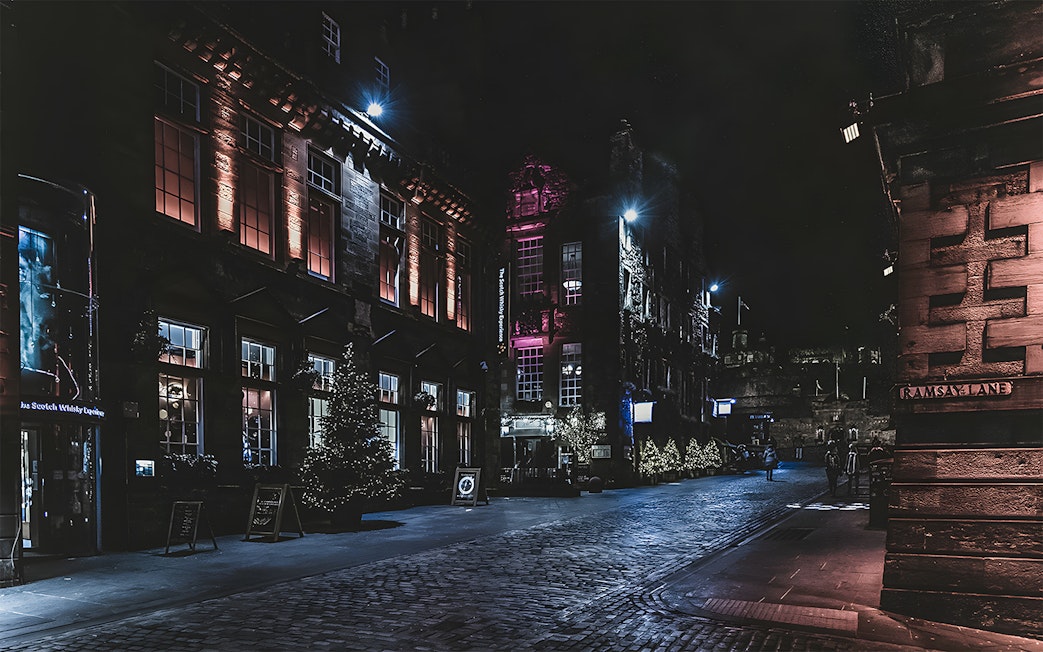Historic street at night with illuminated buildings on the Extreme Paranormal Activity Tour.