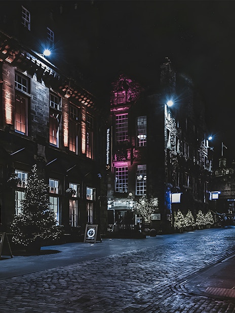 Historic street at night with illuminated buildings on the Extreme Paranormal Activity Tour.