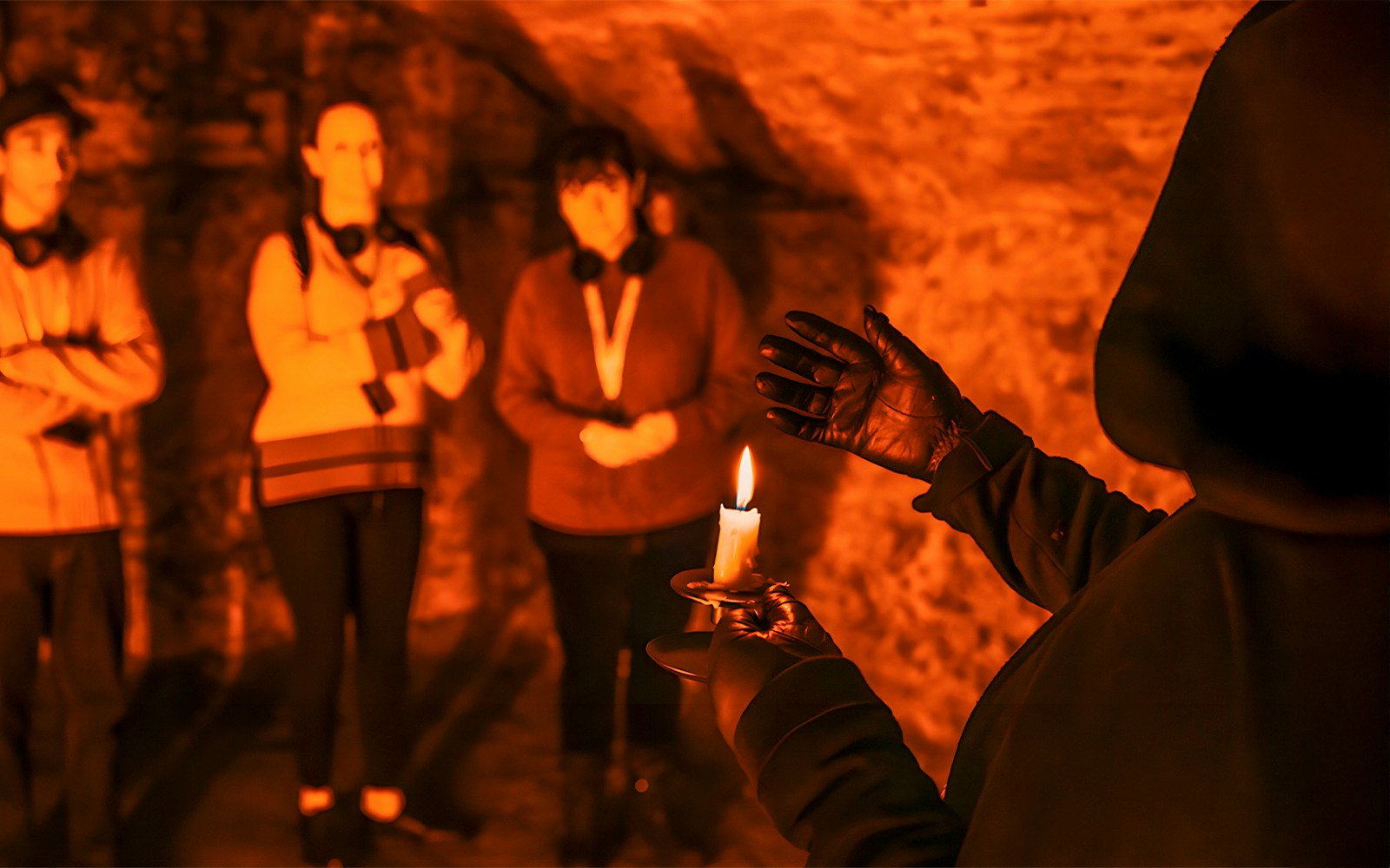 Group exploring Edinburgh underground vaults by candlelight.