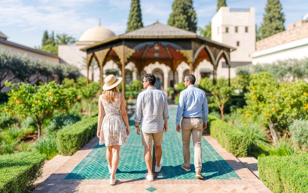 Visitors walking through Jardin Secret garden on a guided tour, surrounded by lush greenery.