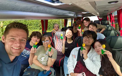 Tour group on a bus holding tulip souvenirs for Giethoorn Self-Guided Boat Rental Tour.