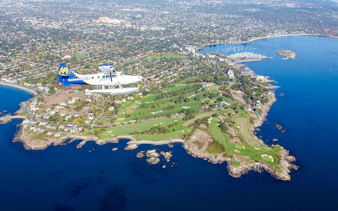 Seaplane flying over Victoria's coastline and islands during scenic tour.
