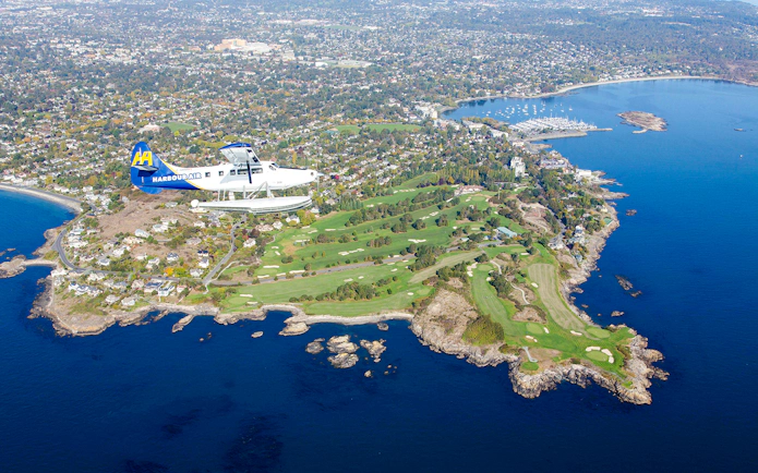 Seaplane flying over Victoria's coastline and islands during scenic tour.