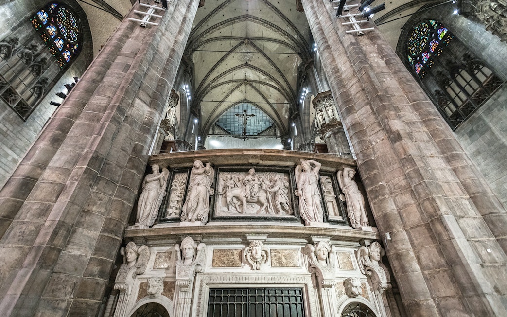 Duomo Milan Cathedral interior with ornate sculptures and vaulted ceiling.