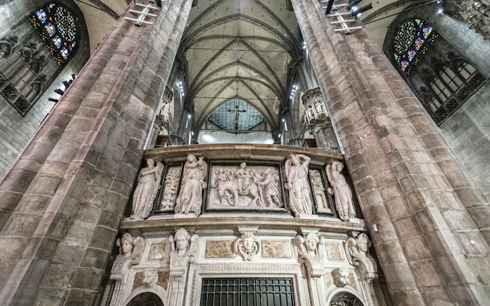 Duomo Milan Cathedral interior with ornate sculptures and vaulted ceiling.