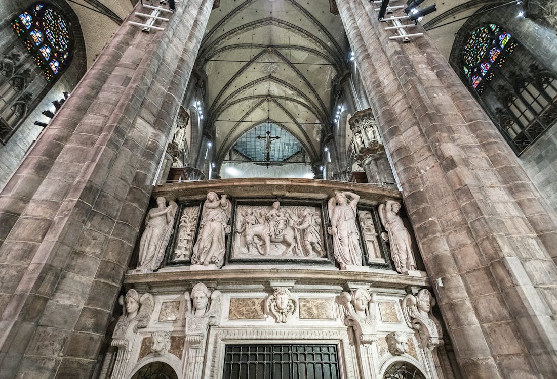 Duomo Milan Cathedral interior with ornate sculptures and vaulted ceiling.