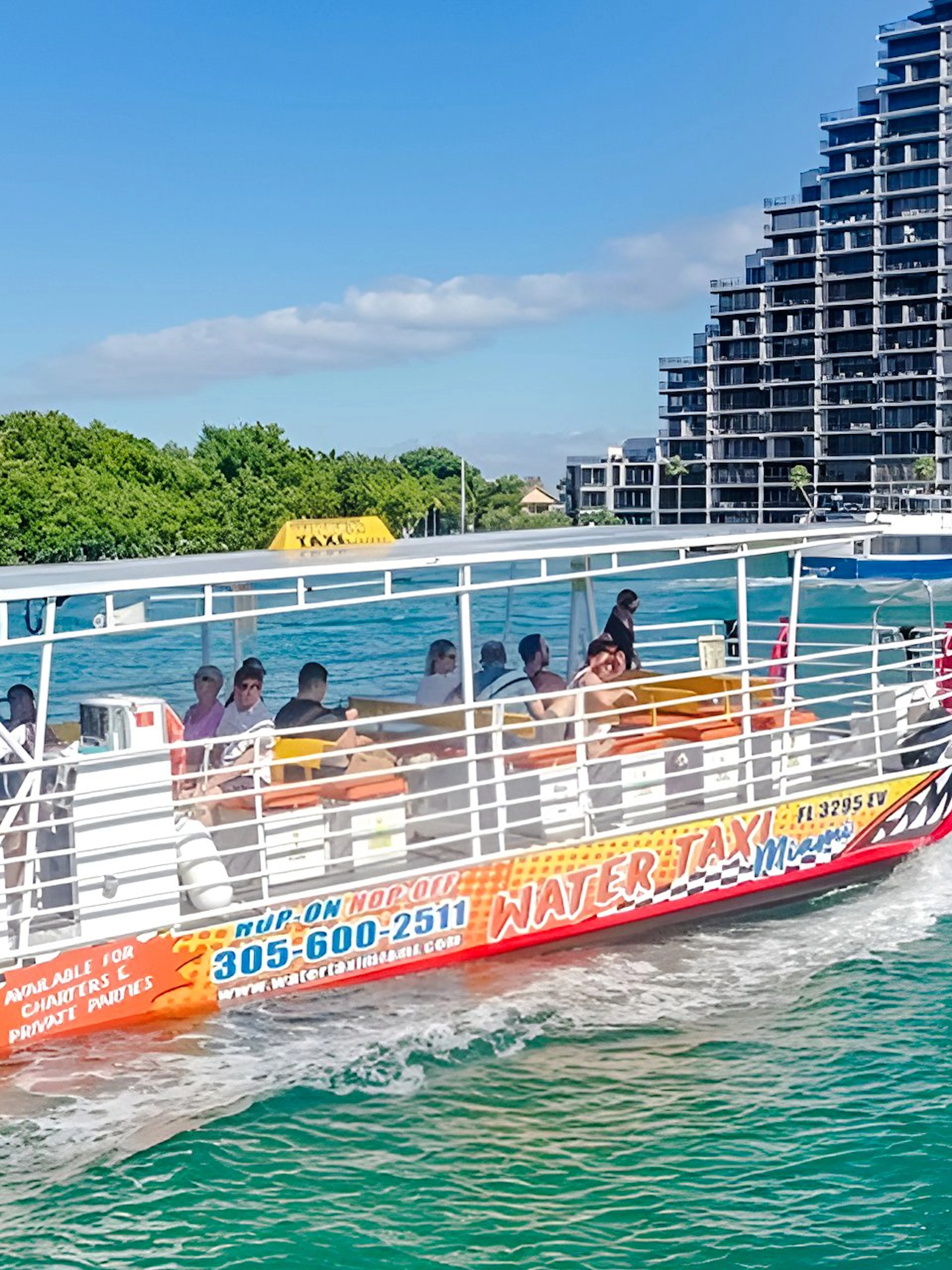 Water taxi cruising near high-rise buildings in Miami.
