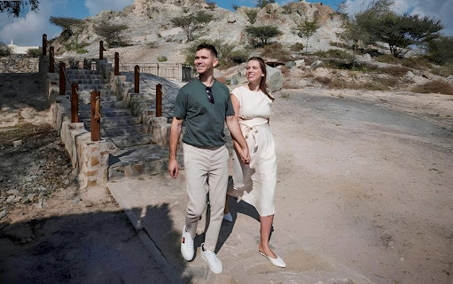 Couple walking near stone steps at Hatta Heritage Village.