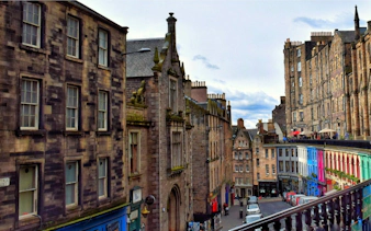 Victoria Street in Edinburgh with colorful shops and historic architecture.