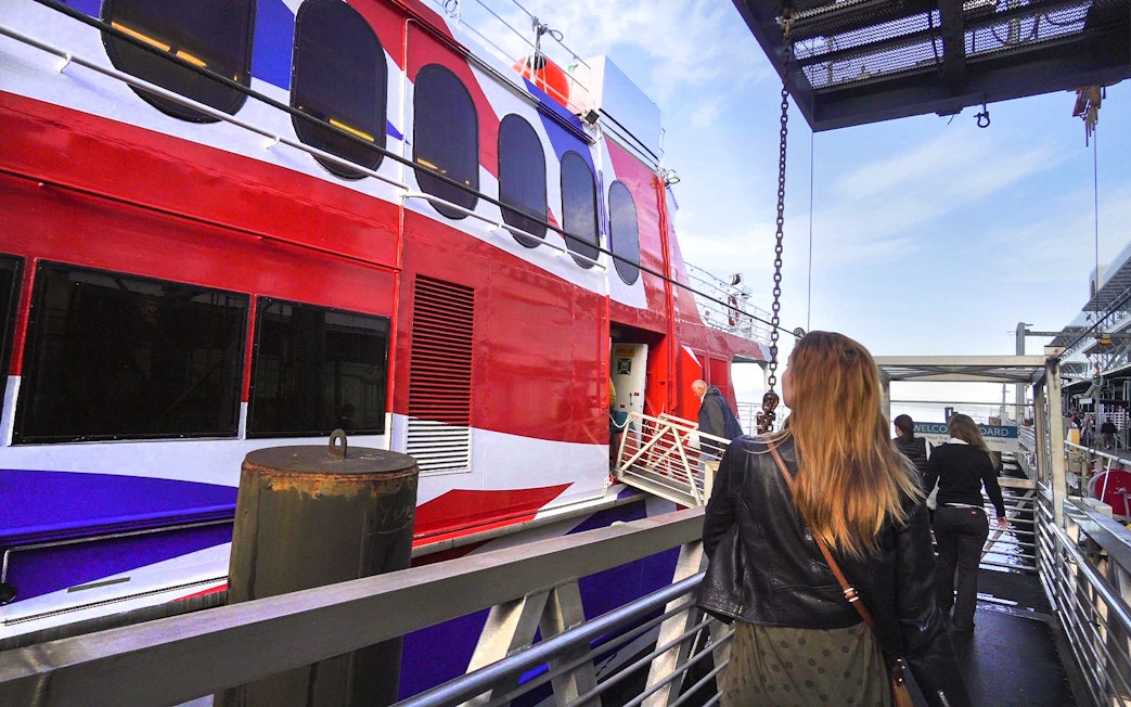 Passengers boarding high-speed ferry from Seattle to Victoria with Puget Sound views.
