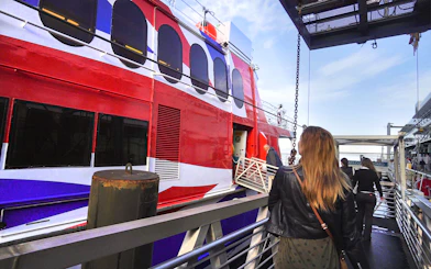Passengers boarding high-speed ferry from Seattle to Victoria with Puget Sound views.