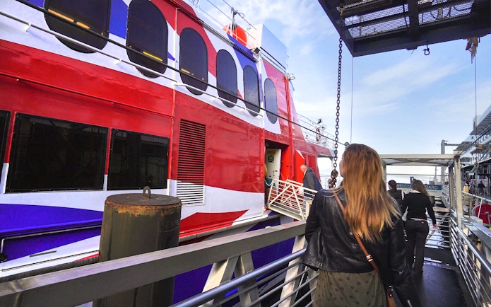 Passengers boarding high-speed ferry from Seattle to Victoria with Puget Sound views.