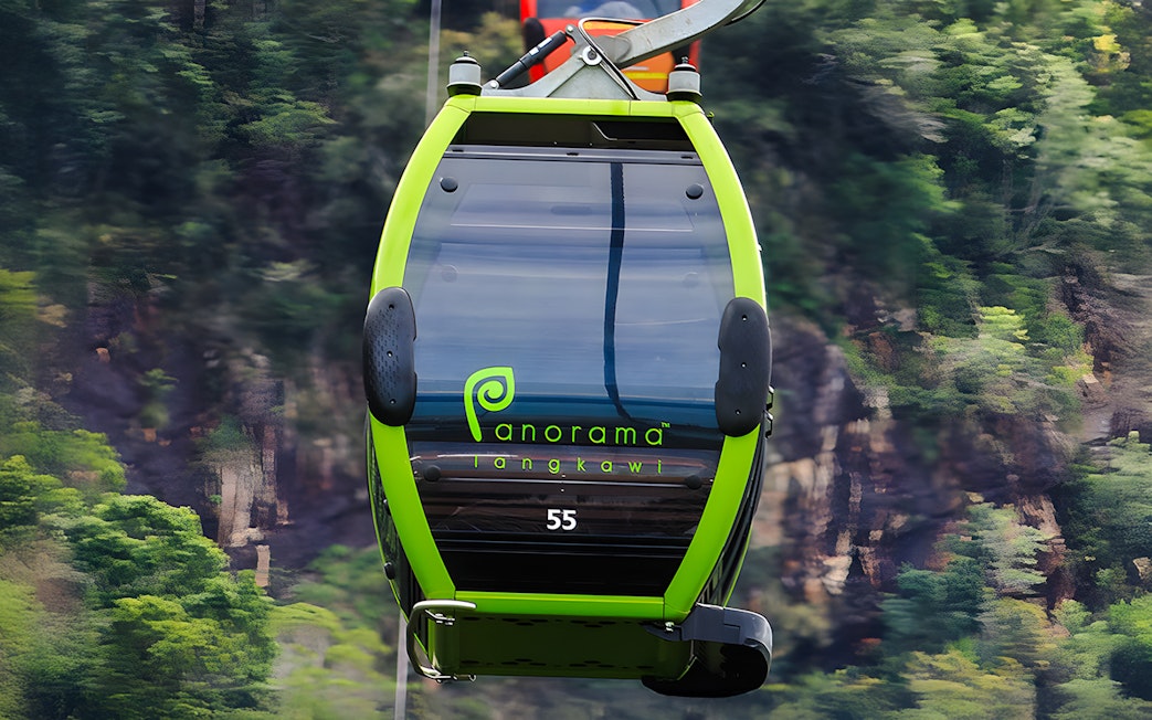 Private gondola on Langkawi cable car with forested hills in the background.