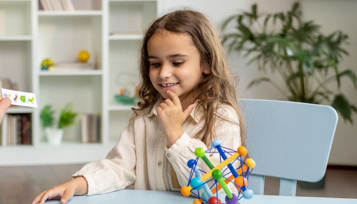 Neurodivergent girl engaging with interactive toys in a sensory-friendly room.