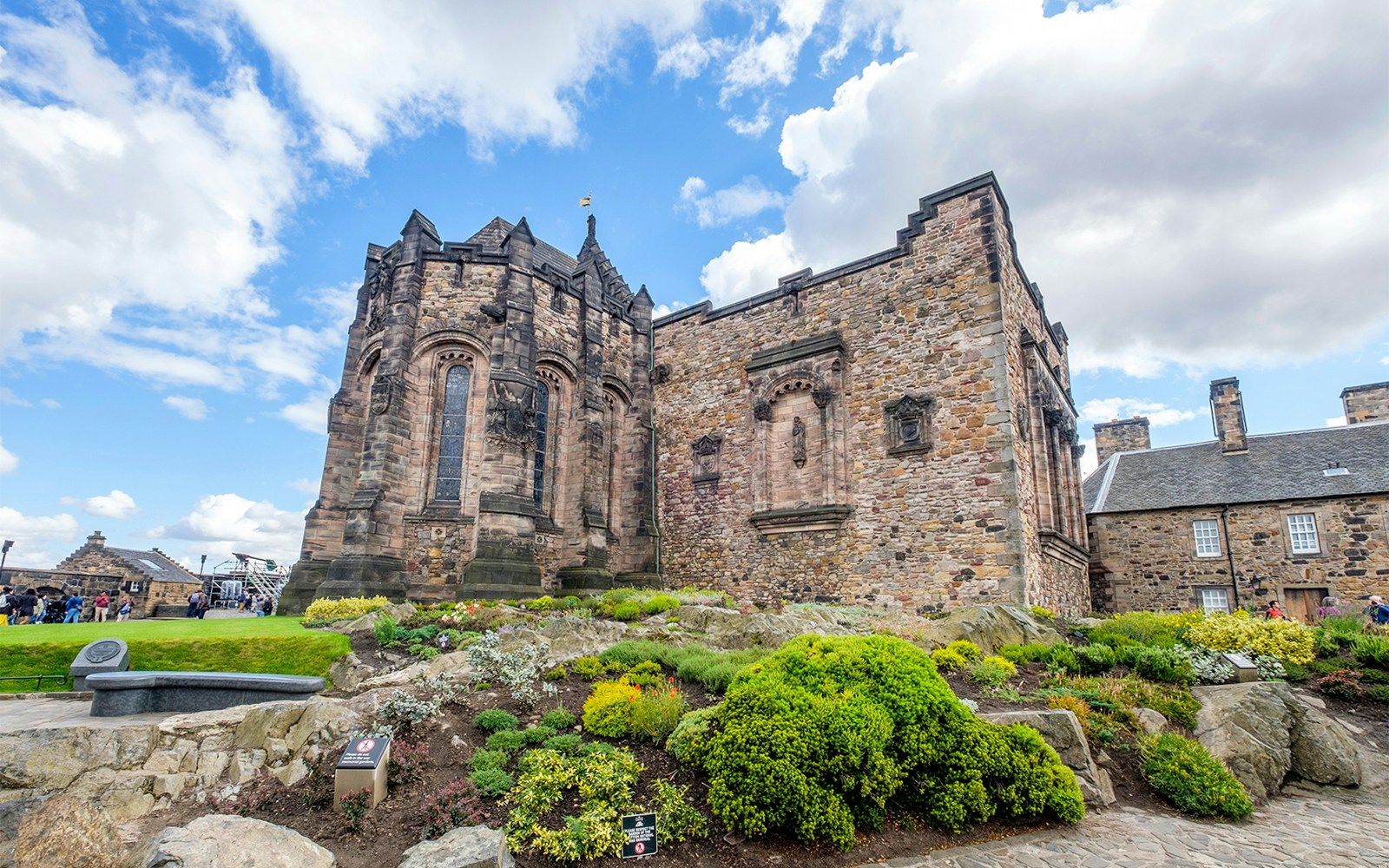 Edinburgh Castle stone building with lush gardens under a blue sky.