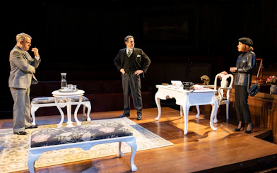 Courtroom scene from "Witness for the Prosecution" play with three actors on stage.