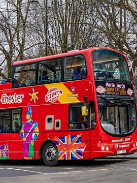 Red double-decker bus for City Sightseeing Chester Hop-on Hop-off tour parked on a street.