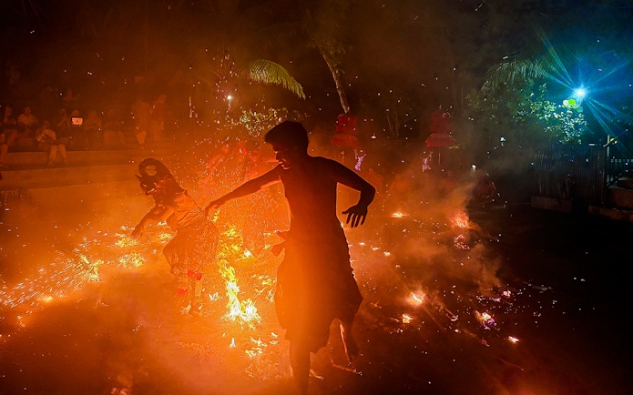 Performers in traditional Balinese attire enact a Ramayana scene with fire in Bali, Indonesia.